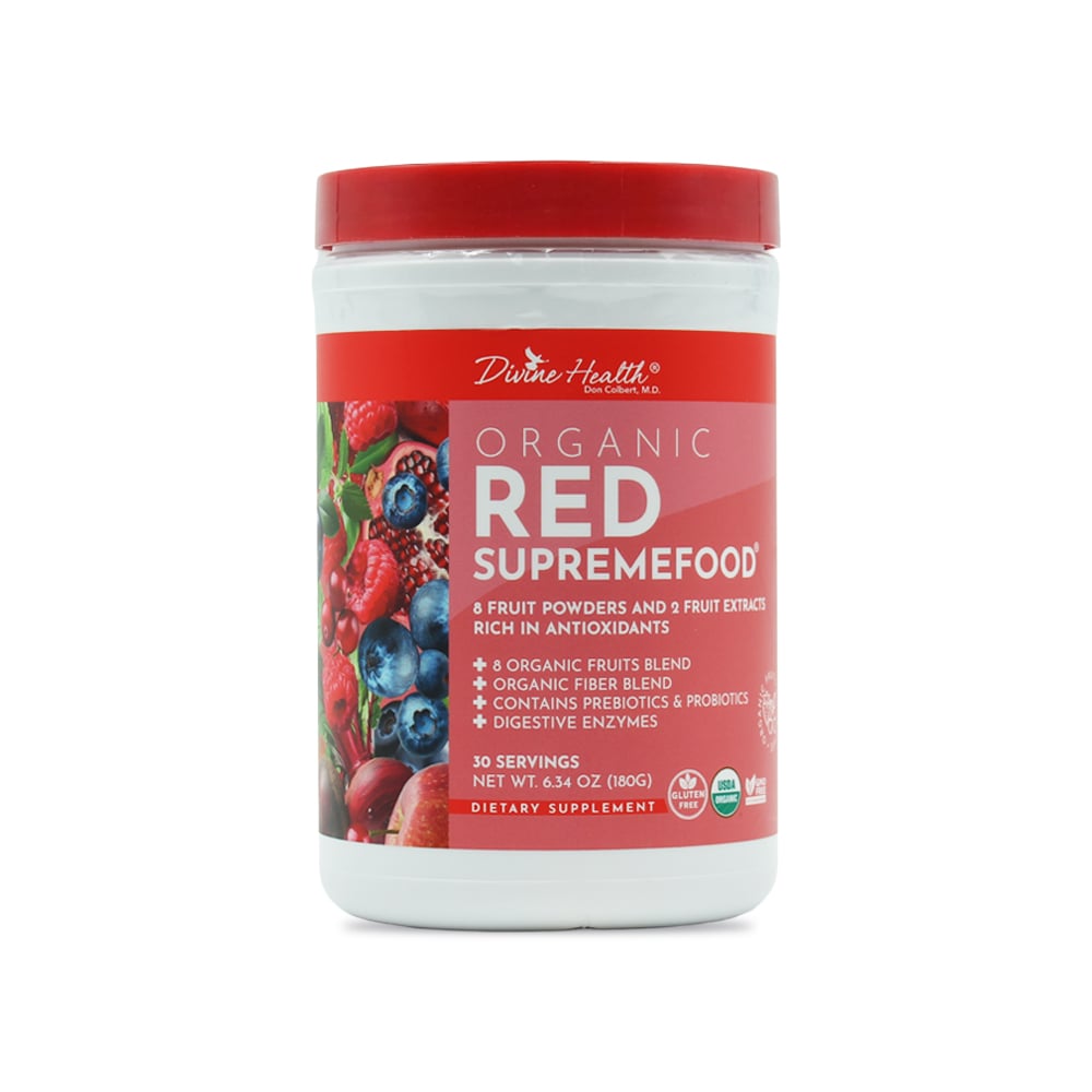 A single white plastic supplement container of Organic Red Supremefood by Divine Health, formulated by Dr. Don Colbert, MD, is shown centered against a clean white background. The container features a red screw-top lid and a full-wrap red label. The front label displays the product name “Organic Red Supremefood” in large white lettering, surrounded by images of red and blue fruits such as berries and pomegranate on the left side. Additional visible label text lists fruit powders, fiber blend, prebiotics, probiotics, and digestive enzymes, along with “30 servings” and the net weight. Certification icons appear near the bottom of the label. The container is upright, front-facing, evenly lit, and isolated with no surrounding props, emphasizing the packaging design, branding, and ingredient imagery.