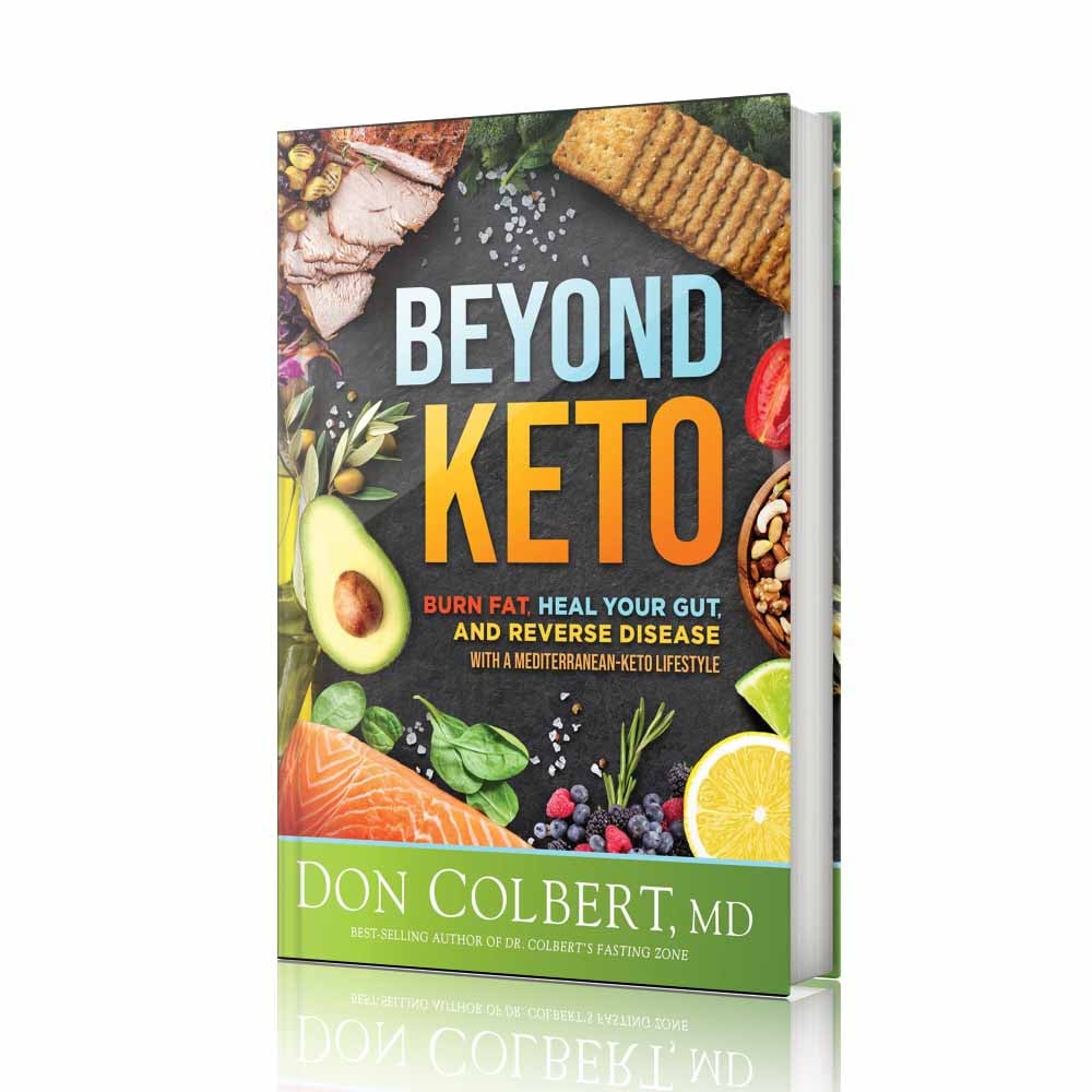 Hardcover book Beyond Keto by Dr. Don Colbert, MD from Divine Health featuring a colorful cover with avocado, salmon, berries, olive oil, and Mediterranean-style foods that support a ketogenic lifestyle. This nutrition and wellness book explains how a Mediterranean-Keto diet can help burn fat, support gut health, and improve metabolic balance. The guide discusses the benefits of probiotics for digestive health, fiber supplements for microbiome support, and nutrition strategies that may include collagen powder and MCT oil powder to promote healthy metabolism, energy production, and long-term wellness through the Divine Health lifestyle approach.