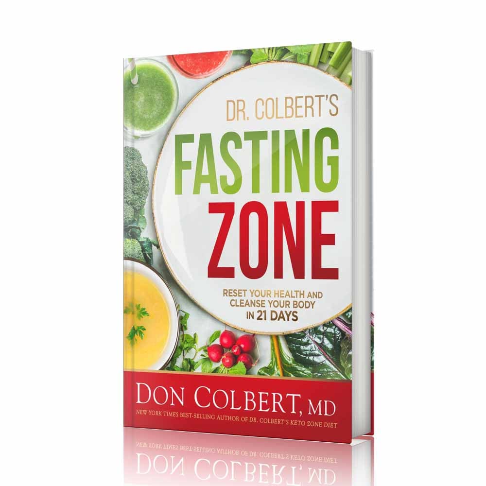 Hardcover book Dr. Colbert’s Fasting Zone by Dr. Don Colbert, MD from Divine Health displayed with a vibrant cover featuring fresh vegetables, leafy greens, soup, and whole foods that represent a fasting and detox lifestyle. This health and nutrition guide teaches how a 21-day fasting program can help support metabolism, promote gut health, and encourage healthy weight management. The book discusses digestive balance through probiotics, microbiome support using fiber supplements, and nutrition strategies that may include collagen powder and MCT oil powder to support energy production, metabolic health, and overall wellness through the Divine Health lifestyle philosophy.
