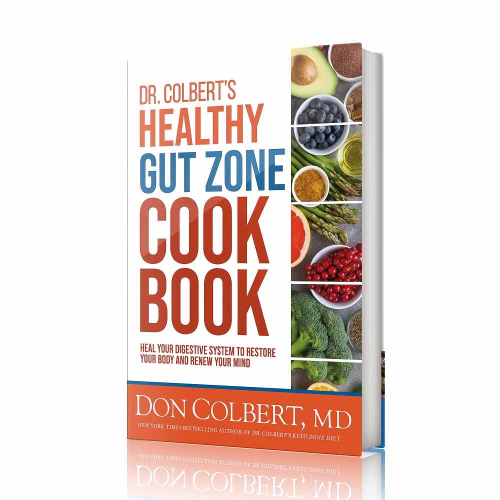 Hardcover book Dr. Colbert’s Healthy Gut Zone Cookbook by Dr. Don Colbert, MD featuring colorful whole foods including avocado, berries, asparagus, broccoli, citrus, olive oil, and nutrient-dense ingredients associated with gut health and digestive wellness. This Divine Health cookbook focuses on recipes designed to support the microbiome and promote digestive balance. The book highlights the importance of gut health through fiber-rich foods that nourish beneficial bacteria and complement probiotics for improved digestion. It also aligns with holistic wellness strategies that include collagen powder for supporting gut lining health and MCT oil powder for clean metabolic energy. As part of the Divine Health Healthy Gut Zone lifestyle, this cookbook helps readers prepare meals that support digestion, improve microbiome balance, and promote long-term wellness through nutrient-dense foods.