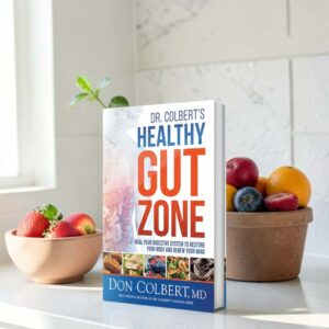 Dr. Colbert’s Healthy Gut Zone softcover book by Dr. Don Colbert, MD from Divine Health featuring a detailed digestive system graphic on the cover. The book focuses on gut health and digestive wellness, explaining how probiotics, prebiotic fiber supplements, microbiome balance, and gut-supporting nutrition strategies may help improve digestion, immune function, nutrient absorption, and overall health.