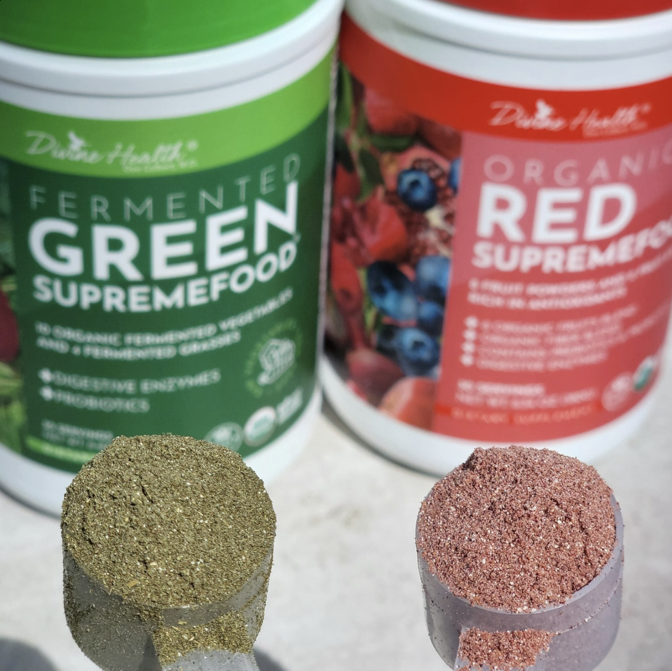 Green Supremefood and Red Supremefood powders by Divine Health with scoops of green and red superfood blends in front of the containers.