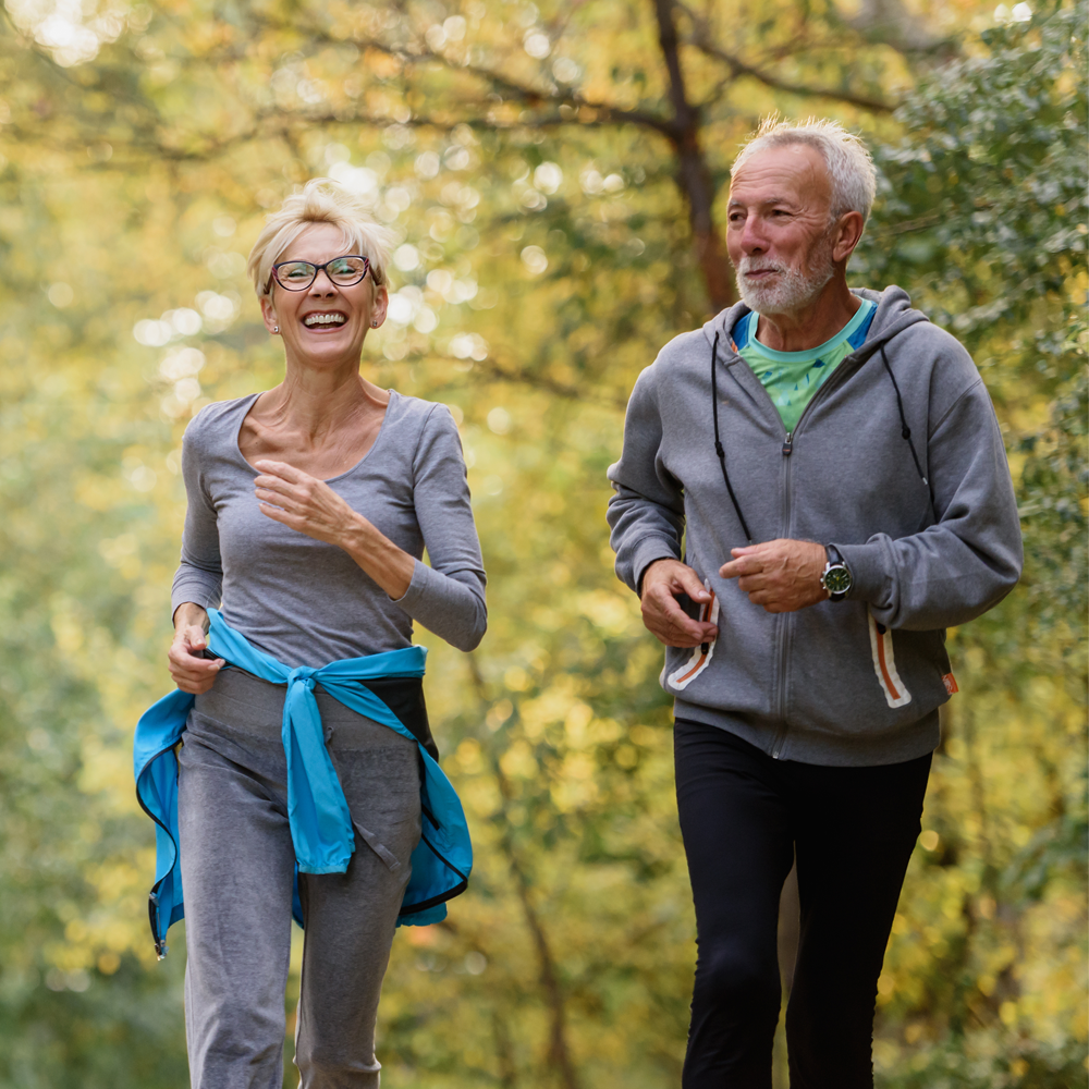 Active couple jogging outdoors for fitness and health in the park