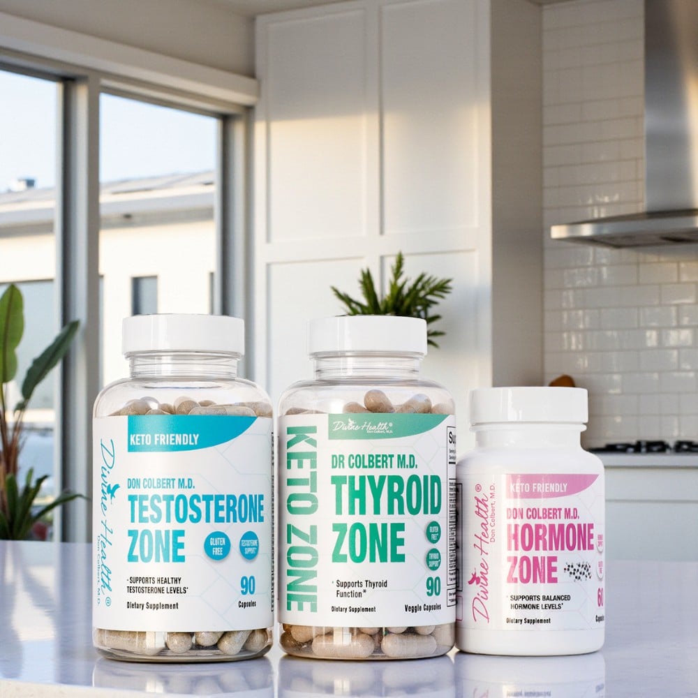 Divine Health Dr. Don Colbert, MD Hormone Zone Maintenance Pack arranged on a polished kitchen counter, featuring three supplement bottles: Testosterone Zone with teal-blue labeling, Thyroid Zone with bold green Keto Zone branding, and Hormone Zone with pink label accents; all bottles contain visible capsules and are set against a modern kitchen backdrop with natural light, plants, cabinets, and stainless-steel appliances.