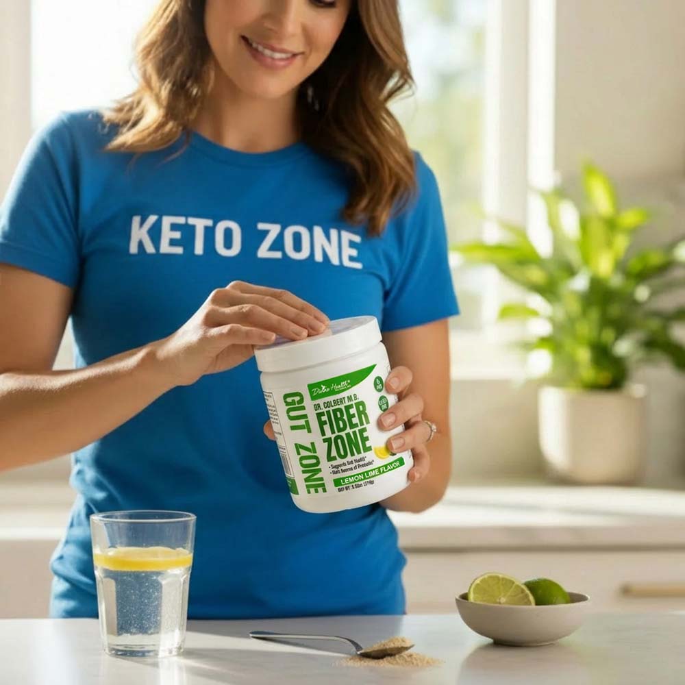 Woman holding Fiber Zone Lemon-Lime fiber powder by Divine Health formulated by Dr. Don Colbert, MD while preparing a fiber drink in a kitchen.