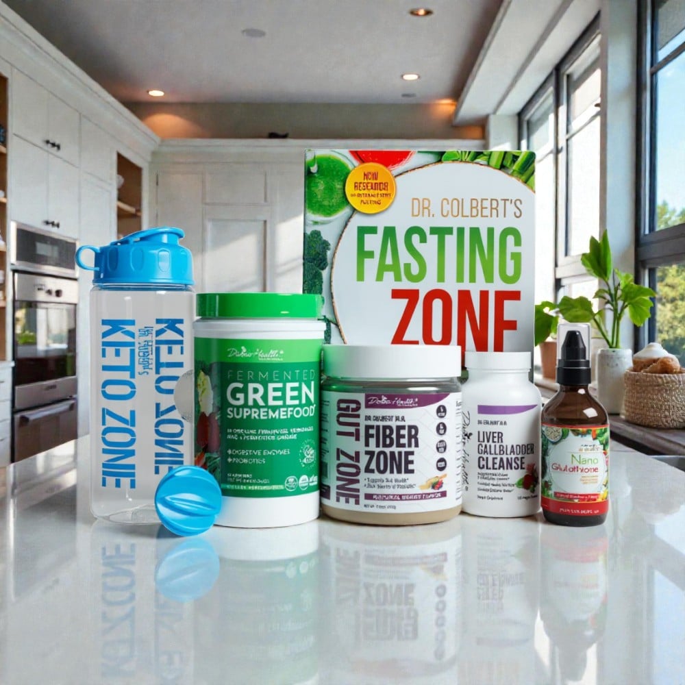 Divine Health Dr. Don Colbert, MD Detox Starter Pack arranged on a polished kitchen countertop, including a blue Keto Zone shaker bottle with mixing ball, Fermented Green Supremefood in a tall green container, Fiber Zone in a white-and-purple tub, Liver Gallbladder Cleanse in a white bottle, Nano Glutathione in a brown glass spray bottle, and Dr. Colbert’s “Fasting Zone” book positioned behind the products. The scene is set in a modern kitchen with bright window lighting, white cabinetry, stainless-steel appliances, and greenery in the background.