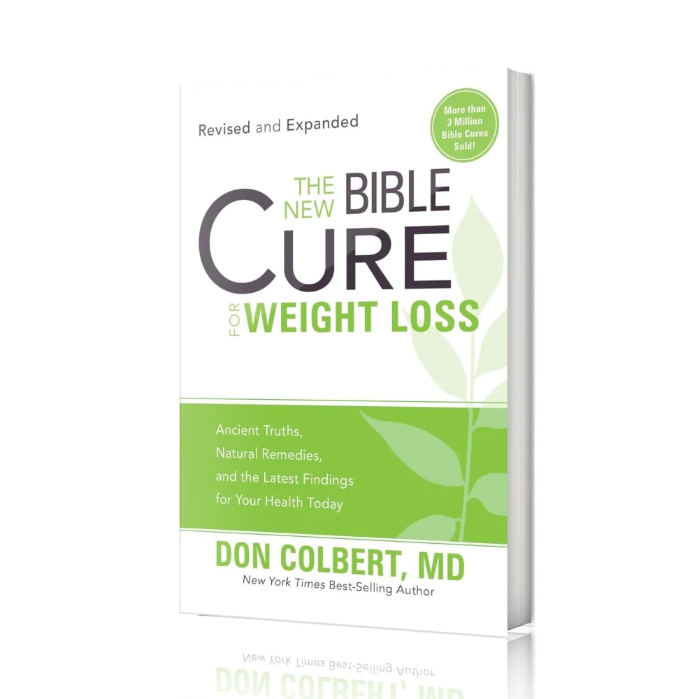 A softcover paperback copy of “The New Bible Cure for Weight Loss” by Don Colbert, MD is shown standing upright against a clean white background, slightly angled to reveal the front cover and the thickness of the pages along the right edge. The book features a minimalist design with a white upper section, bold black lettering for the word “CURE,” and green text for “Weight Loss.” A green horizontal band runs across the lower third of the cover, decorated with a subtle leaf motif symbolizing growth and renewal. At the top of the cover, the phrase “Revised and Expanded” appears, while a circular green badge states “More than 3 Million Bible Cures Sold.” The author’s name, Don Colbert, MD, is printed prominently at the bottom. The clean, studio-style presentation places full focus on the book itself, emphasizing clarity, simplicity, and balance.