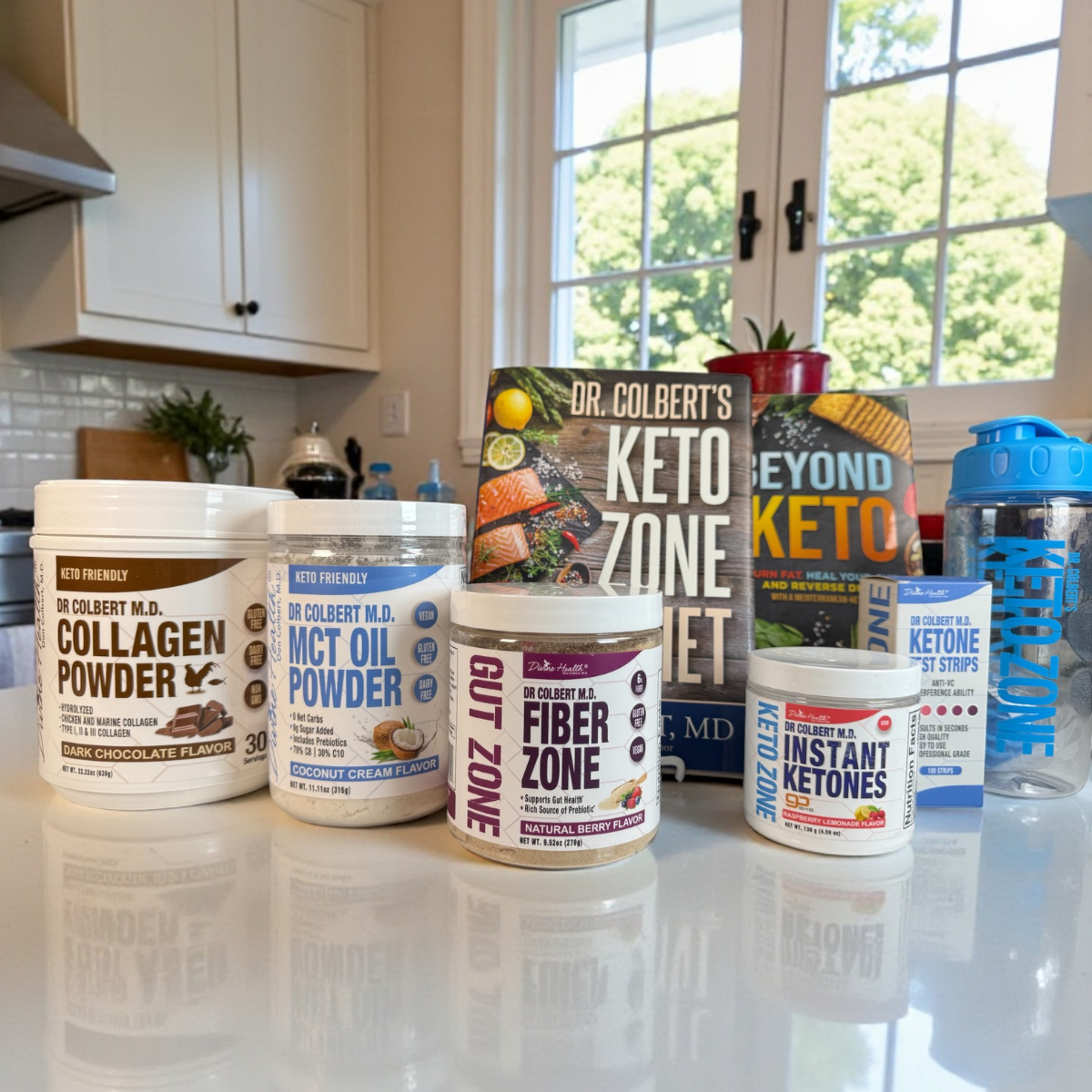 Keto Zone Complete Pack with MCT Oil Powder, Instant Ketones, Fiber Zone, Ketone Test Strips, and Keto Zone books on a countertop.