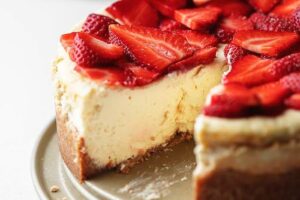 Slice of keto cheesecake with almond flour crust on a white plate