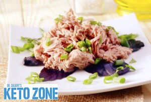 Mediterranean keto tuna salad with cucumber, radish, kalamata olives and fresh herbs in a white bowl