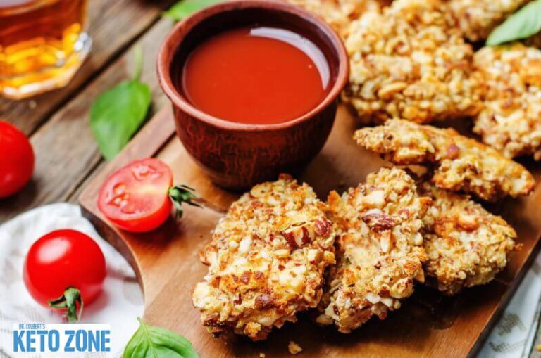 Crispy keto chicken tenders with a low carb coating on a serving board
