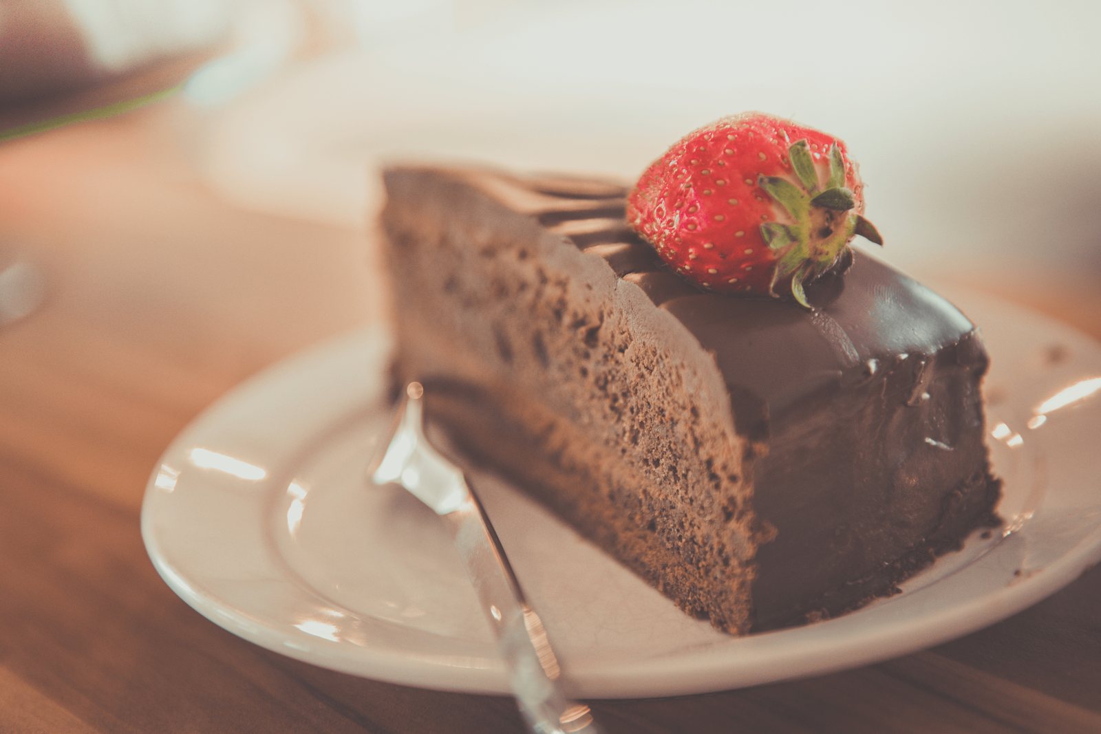 A slice of rich keto chocolate cake on a plate, a sugar free and gluten free low carb dessert